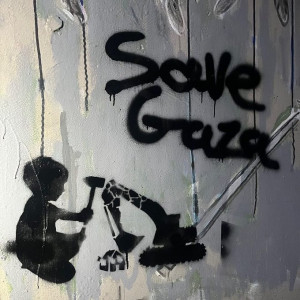 Graffiti reading 'Save Gaza' and a stencil painted image of a child hitting a bulldozer with a hammer, breaking apart the bulldozer. Seen in Portland Oregon