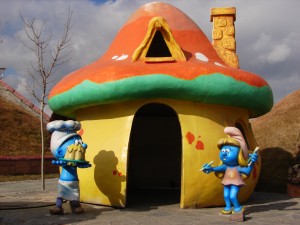 Two Smurfs in front of a Mushroom house