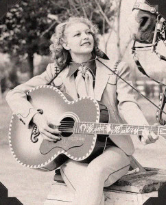 Vintage image of Cindy Walker playing Gene Autry's guitar