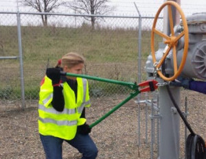 Emily Johnston wielding bolt cutters at a pipeline valve